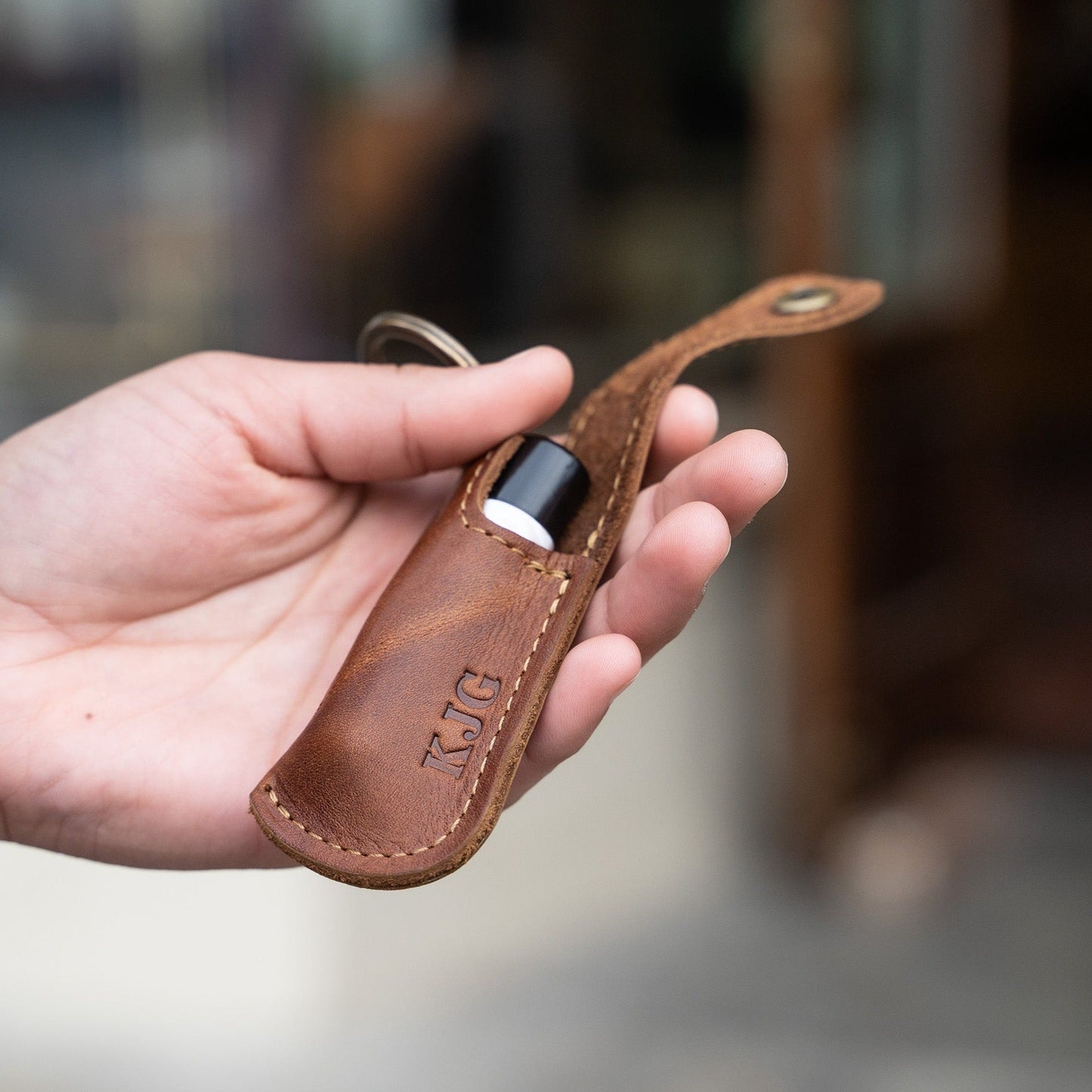 Keychain lip balm holder featuring button snap closure. Made with full-grain American leather. Customize with your initials. Makes for the perfect gift or stocking stuffer. Available in black or brown leather.