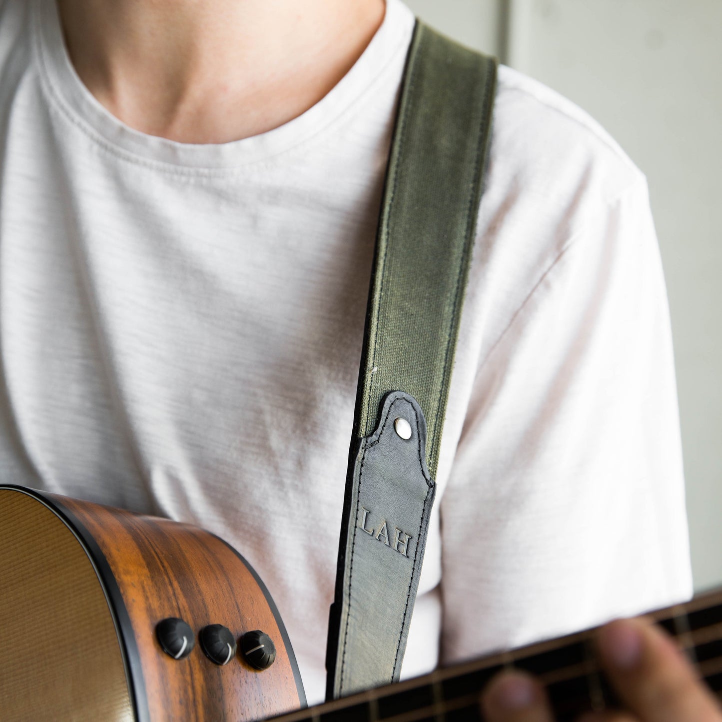 Guitar strap made of green canvas and black leather with personalized initials